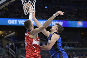 Wizards center Kristaps Porzingis blocks a shot by Magic forward Franz Wagner during Washington's 119-100 win on Friday.