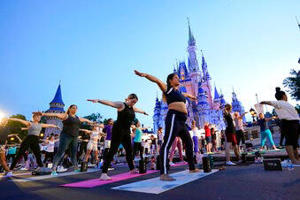 About 2,000 cast members practice sunrise yoga in front of Walt Disney World's Cinderella Castle on June 21, 2022 in Lake Buena Vista, Florida. (AP Photo/John Roux) Associated Press