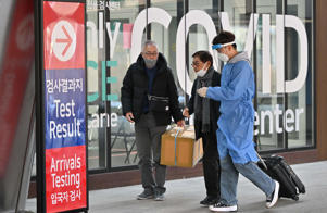 A medical worker leads travelers from China in front of a COVID-19 testing center at Incheon International Airport, west of Seoul, South Korea, January 3, 2023. / Photo by JUNG YEON-JE/AFP/Getty