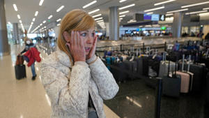 Traveler Shana Schiffer of Chicago reacts after receiving a missing Christmas bag from the Southwest Airlines baggage claim area at Salt Lake City International Airport, Thursday, Dec. 29, 2022, in Salt Lake City.