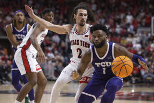 TCU's Mike Miles Jr. (1) dunks as TX Tech's Pop Isaacs (2) defends during the second half of an NCAA college basketball game on Saturday, Feb. 25, 2023 in Lubbock, Texas. (AP Photo/Chase Seabolt)