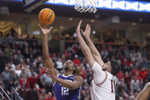 TCU's Xavier Cork (12) shoots Texas Tech's Fardous Aimak (11) during the second half of an NCAA college basketball game on Saturday, Feb. 25, 2023 in Lubbock, Texas. (AP Photo/Chase Seabolt)
