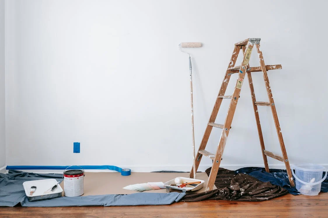 wooden ladder standing beside tools for painting